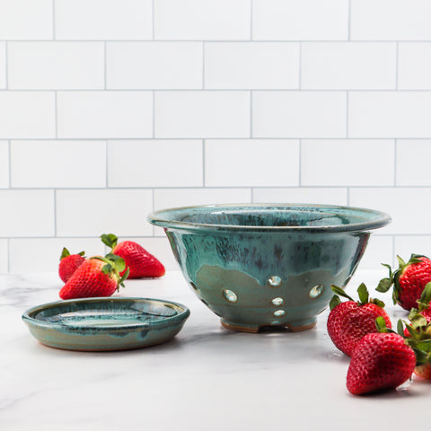 Light blue ceramic colander and strawberries in kitchen counter