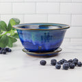 Blue ceramic colander and blueberries on kitchen counter