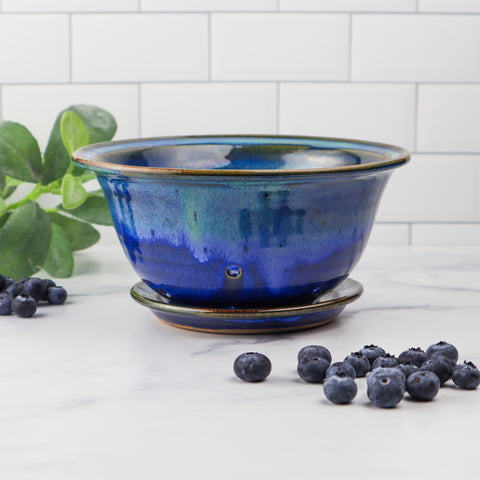 Blue ceramic colander and blueberries on kitchen counter